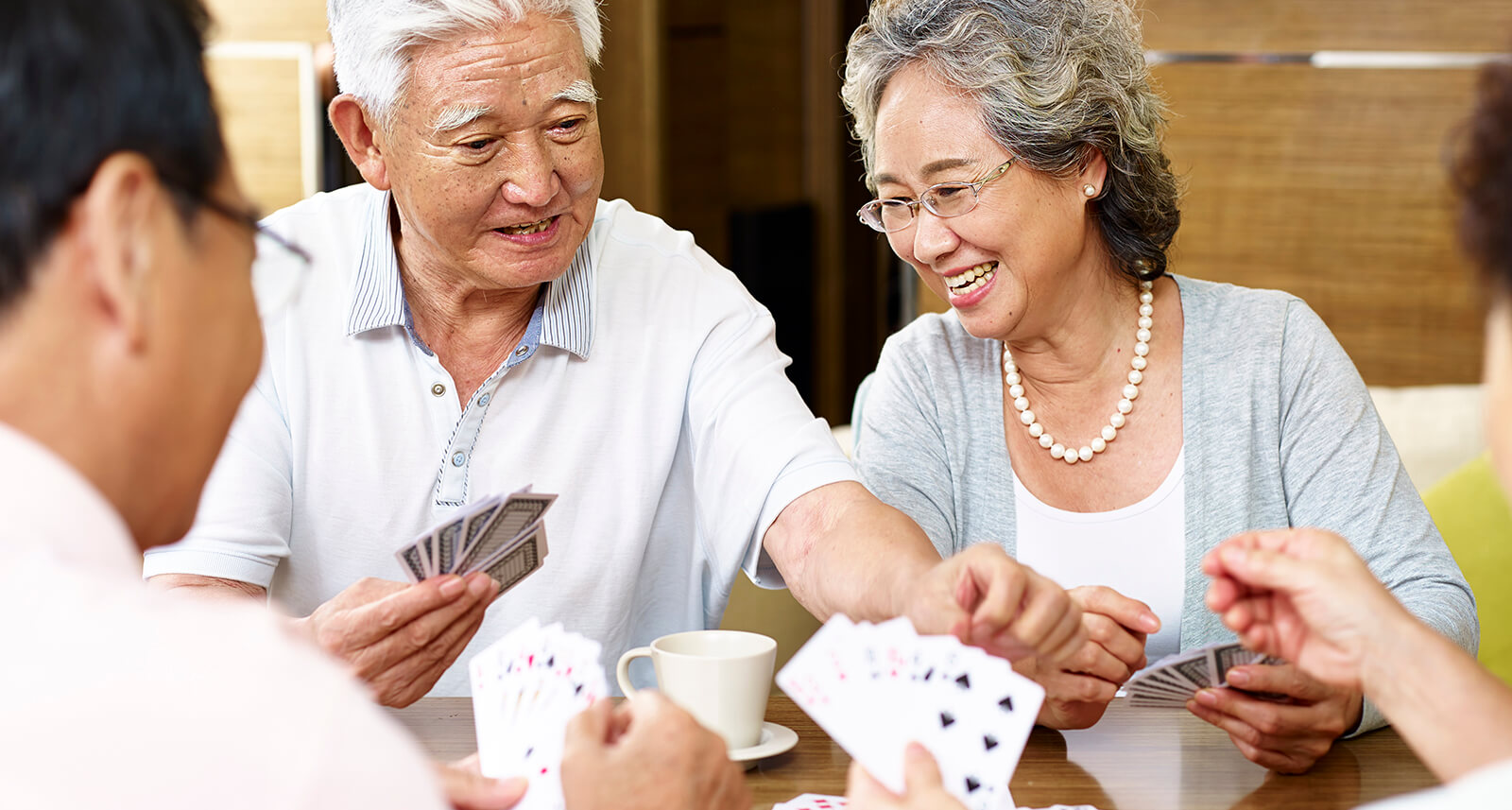 Group of mature people smiling while playing cards
