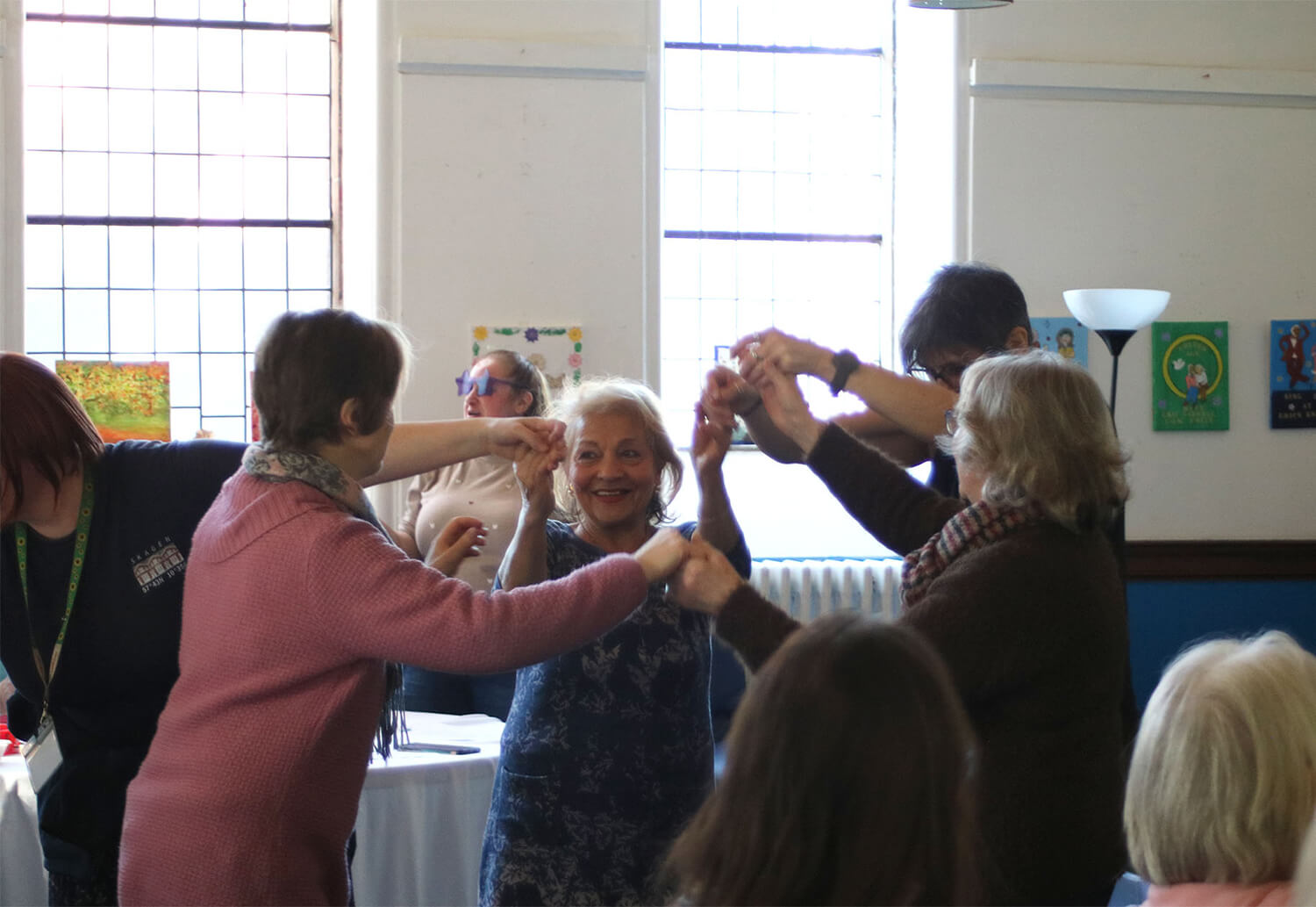 A group of Elderly people dancing and smiling